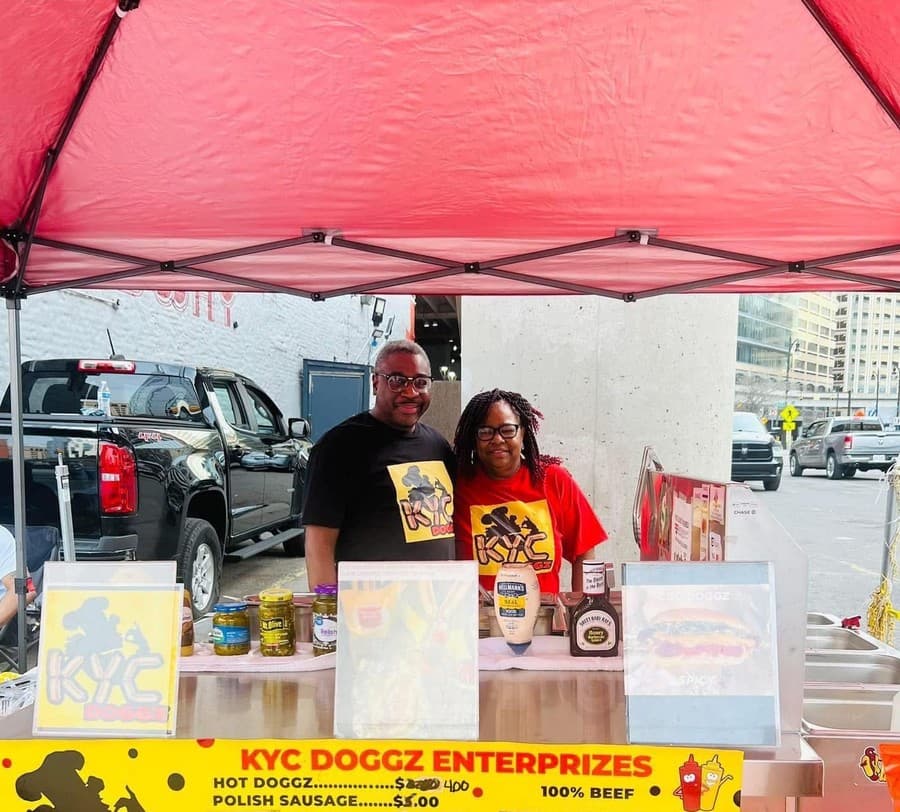 Mr. and Mrs. Cannady behind the KYC Doggz stand in downtown Detroit