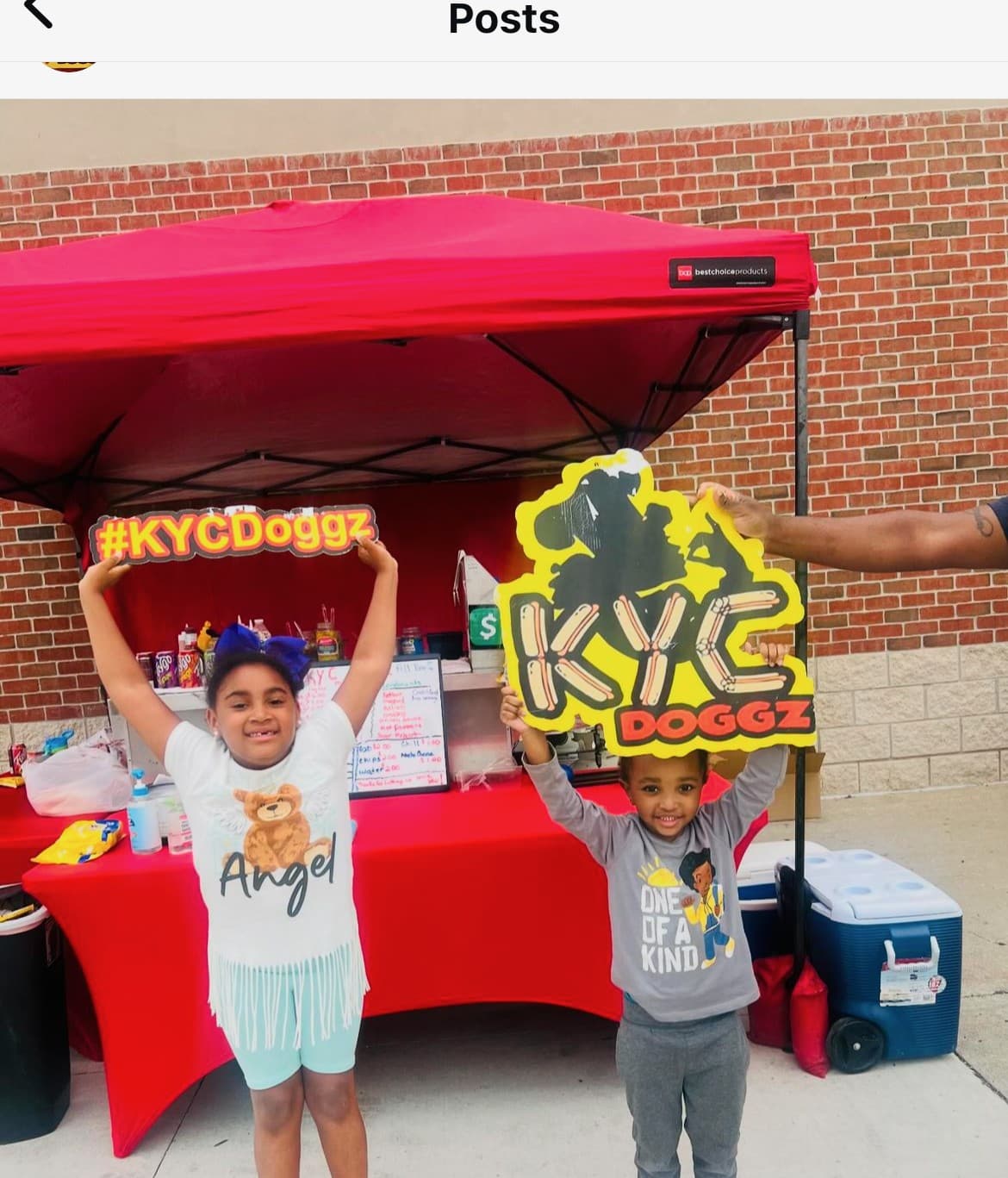 Kids holding KYC Doggz signs at the cart