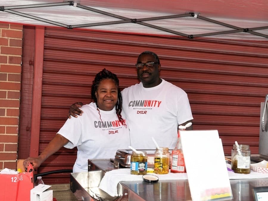 Mr. and Mrs. Cannady in Community shirts behind the cart