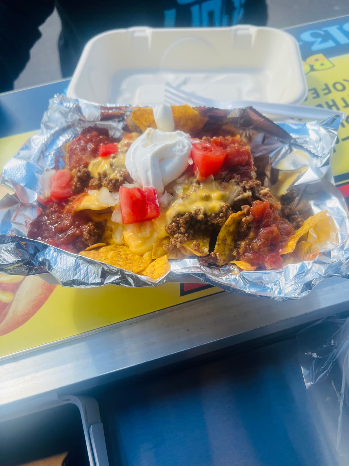 Loaded meat nachos with sour cream, tomatoes, and cheese